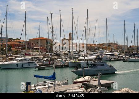 Un motoscafo della polizia Finanza Italiana che entra nel porto del villaggio di pescatori in estate, San Vincenzo, Livorno, Toscana, Italia Foto Stock