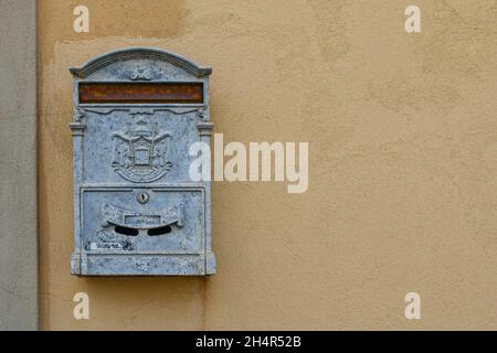 Primo piano di una cassetta postale in metallo grigio appesa al muro di una vecchia casa, Toscana, Italia Foto Stock