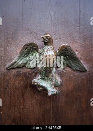 Primo piano di una maniglia in bronzo su una porta marrone a Venezia (Italia), a forma di uccello Foto Stock