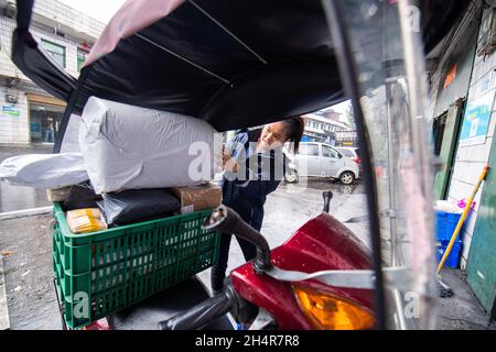 (211104) -- LEIYANG, 4 novembre 2021 (Xinhua) -- Hu Xia carica i pacchi per la consegna in una stazione di consegna rurale nella città di Huangshi a Leiyang, provincia centrale di Hunan della Cina, 3 novembre 2021. HU Xia è una deliverywoman post-90 che fornisce il servizio di consegna per quattro villaggi nella città di Huangshi. Negli ultimi sette anni, il numero di ordini di consegna nelle aree rurali locali è aumentato da meno di 10 al giorno a più di 200. Oltre a consegnare i pacchetti, Hu aiuta anche gli abitanti del villaggio a vendere germogli di bambù, uova e altre specialità agricole attraverso il negozio online. La sua stazione di consegna è diventata uno dei mo Foto Stock