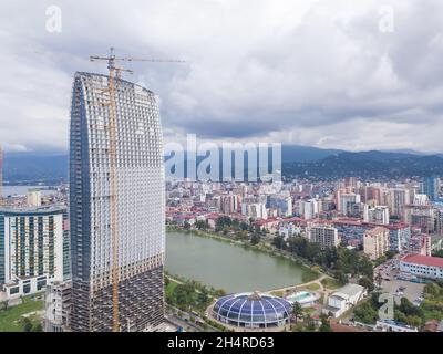 Vista con drone del sito di costruzione di un hotel a più piani sulla prima costa vicino al lago di Batumi. Foto Stock