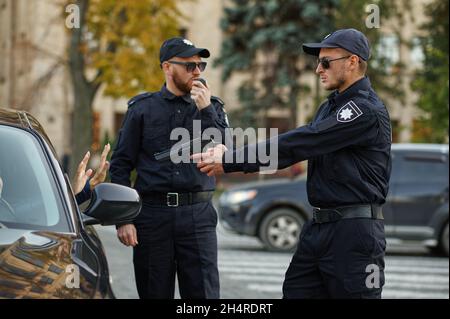 Poliziotti con arma arrestare autista femminile Foto Stock