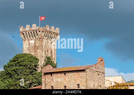 La tradizionale bandiera bianca e rossa di Pisa sorvola l'antica fortezza di Vicopisano, Italia, contro un cielo drammatico Foto Stock