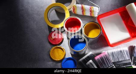 Lattine di vernice e pennelli di dimensioni diverse per la decorazione domestica. Foto Stock
