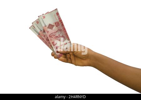 Mano giusta che tiene 3D merended tanzanian shilling note isolate su sfondo bianco Foto Stock