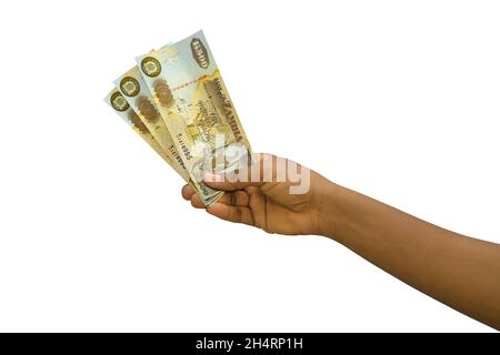 Mano giusta che tiene 3D reso Zambian Kwacha note isolate su sfondo bianco Foto Stock