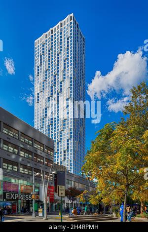 11 Hoyt Street nel centro di Brooklyn è un condominio residenziale con una facciata bianca ondulata unica di pannelli in cemento prefabbricati e un campo automobilistico. Foto Stock