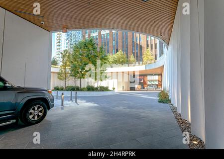 11 Hoyt Street nel centro di Brooklyn è un condominio residenziale con una facciata bianca ondulata unica di pannelli in cemento prefabbricati e un campo automobilistico. Foto Stock