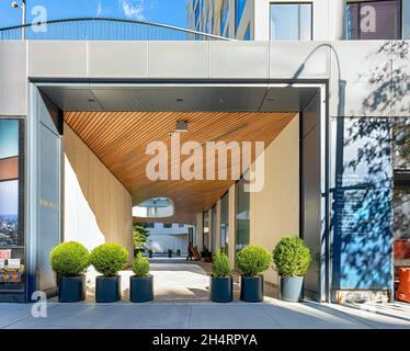 11 Hoyt Street nel centro di Brooklyn è un condominio residenziale con una facciata bianca ondulata unica di pannelli in cemento prefabbricati e un campo automobilistico. Foto Stock