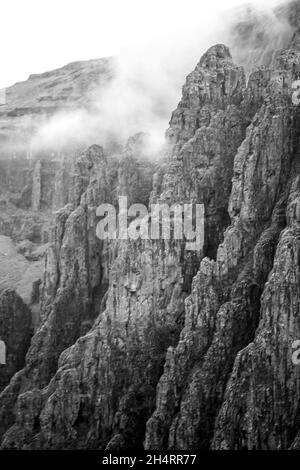 Vista ravvicinata delle ripide scogliere frastagliate dei Monti Drakensberg in Monocromo, lungo il confine tra Sud Africa e Lesotho. Queste leggendarie cricca Foto Stock