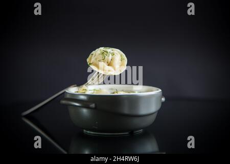 gnocchi bolliti con carne ripieno in una ciotola sul tavolo Foto Stock