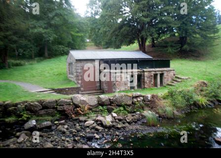 Rocce lago e costruzione vicino alla turbina a vite a Cragside, Rothbury, Northumberland, Inghilterra, Regno Unito, Regno Unito Foto Stock