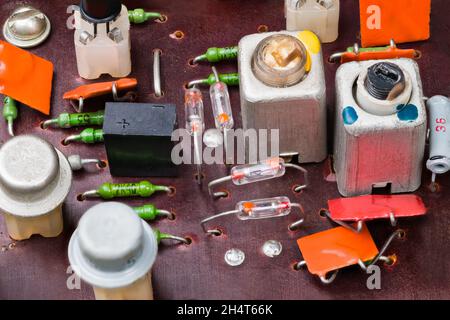 Transistor e diodi retro germanio, condensatori elettrolitici e ceramici, resistenze al carbonio, bobine in alluminio con nucleo in ferrite a vite su scheda a circuito stampato. Foto Stock