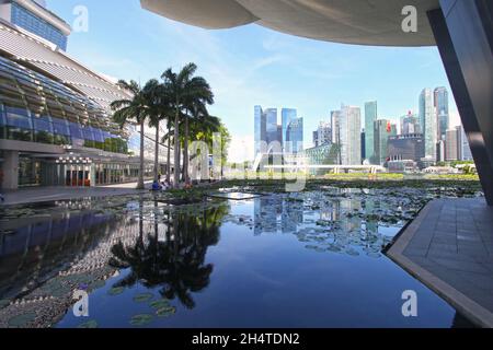 Il Museo ArtScience a Marina Bay Sands con il centro commerciale Shoppes sulla sinistra e il famoso quartiere finanziario di Singapore sullo sfondo. Foto Stock