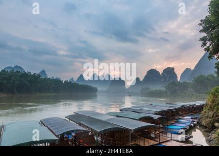 All'alba sopra le barche del tour sul fiume li e le colline carsiche calcaree a Yangshuo, Cina. Foto Stock