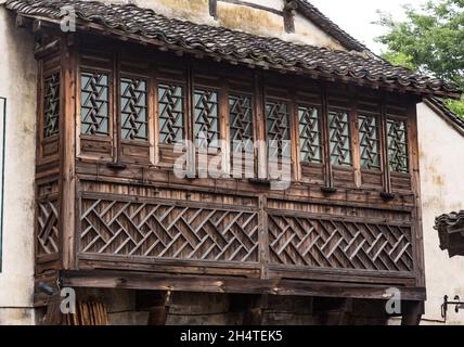 Dettaglio architettonico di traliccio in legno sulle finestre un'antica dimora tradizionale. Wuzhen, Cina. Foto Stock