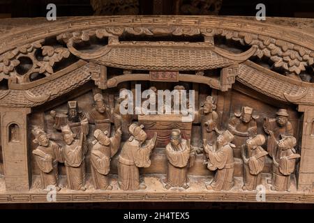 Funzionari cinesi su un antico letto in legno intagliato in una casa storica a Wuzhen, Cina. Foto Stock