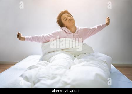 African confortevole Woman Wake Up. Sonno confortevole Foto Stock