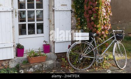 Bici parcheggiata contro una porta aperta Foto Stock