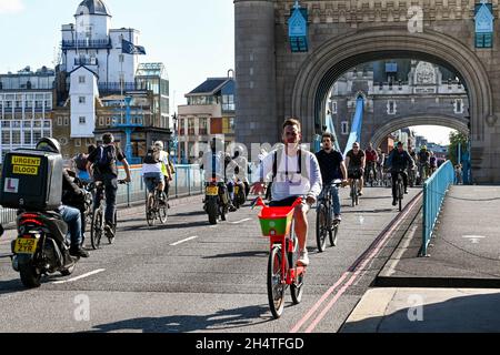 Londra, Inghilterra - Agosto 2021: Le persone che pedalano e guidano in moto attraverso Tower Bridge Foto Stock