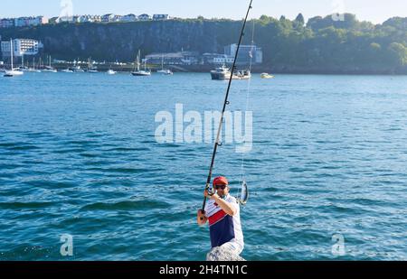 brixham, devon. Maggio 31, 2021. L'uomo mostra alla gente il suo successo di pesca sulla canna da pesca. Giornata felice di pesca sul mare Foto Stock