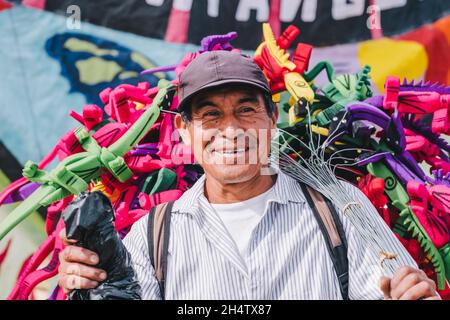 Un uomo felice che vende giocattoli durante il Festival del Kite Gigante a Sumpango, Guatemala Foto Stock