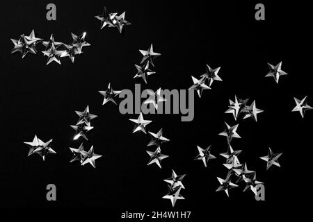 Stelle argento su sfondo nero. Sfondo astratto. Motivo a stella metallico per striscioni o biglietti per le festività Foto Stock