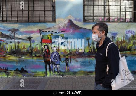 Santiago, Metropolitana, Cile. 4 novembre 2021. Un uomo con maschera cammina di fronte ad un murale dipinto a sostegno delle Mapuches. (Credit Image: © Matias Basualdo/ZUMA Press Wire) Foto Stock