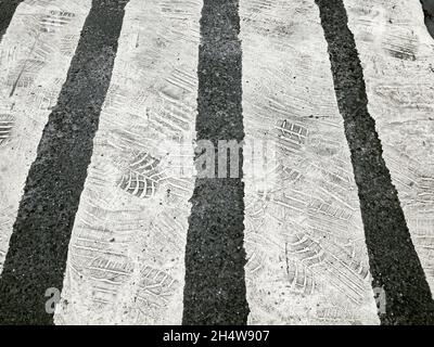 incrocio con zebra bianca. vecchia segnaletica stradale con impronte di pneumatici. Foto Stock