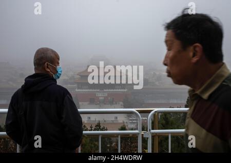 Pechino, Cina. 05 novembre 2021. La gente guarda la Città Proibita durante una giornata inquinata a Pechino, Cina il 05/11/2021 la Cina, il più grande emettitore di anidride carbonica del mondo, ha promesso di diventare carbonio neutro prima del 2060 da Wiktor Dabkowski credito: dpa / Alamy Live News Foto Stock