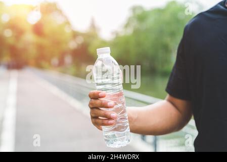 Giovane corridore del fitness che beve una bottiglia d'acqua. Foto Stock