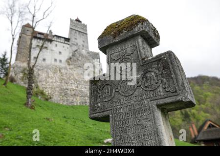 Bran, Romania - 8 maggio 2021: Croce medievale in pietra al Castello di Bran, noto anche come Castello di Dracula in Transilvania, Romania. Foto Stock
