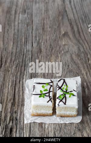Fette di torta alla vaniglia su un rustico tavolo di legno Foto Stock