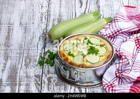 Zucchine e quiche di formaggio feta su tavola di legno bianco Foto Stock