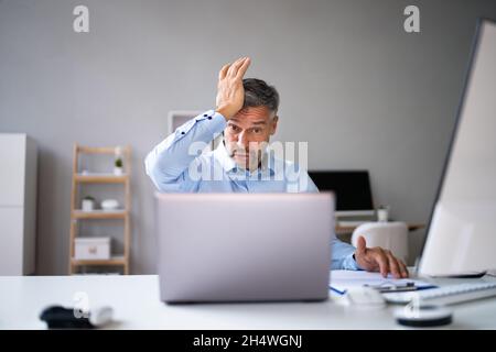 Computer laptop sorpresa al posto di lavoro. Uomo maturo Password dimenticata Foto Stock