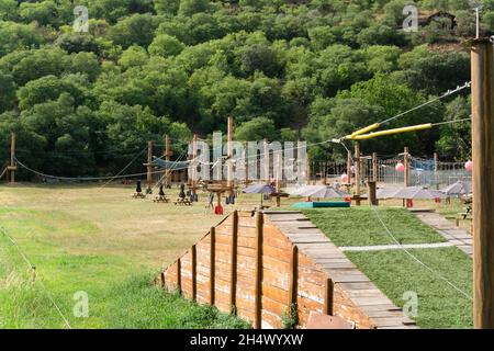 Lleida, SPAGNA - 27 LUGLIO 2021: Zip line da 100 metri e altri giochi in un parco avventura per bambini Foto Stock