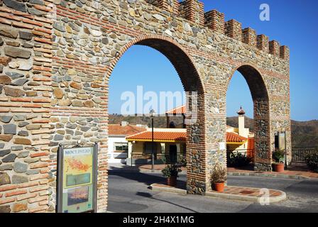 Vista attraverso l'arco di ingresso in stile castello, villaggio bianco (pueblo blanco), Moclinejo, Spagna. Foto Stock