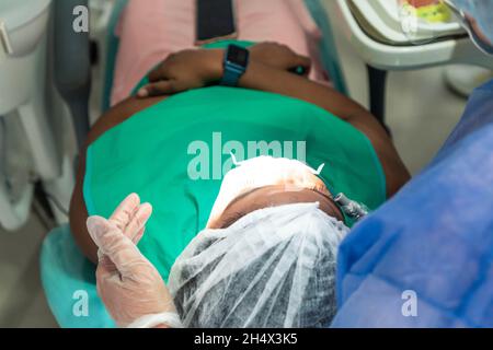 Dentista con strumenti dentali in mano. Dentista al lavoro con guanti e attrezzi in mano. Foto Stock