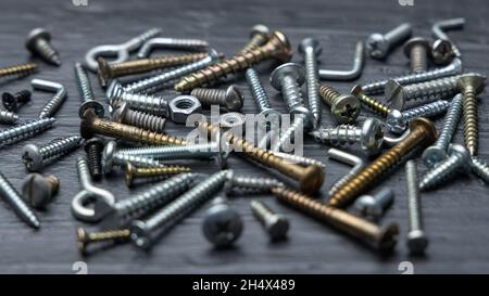 Viti e dadi da costruzione su sfondo nero Foto Stock