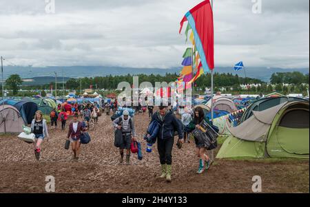 Festival Goers portando le loro attrezzature da campeggio attraverso il fango al Kendal Calling Festival a Lowther Deer Park il 08 agosto 2015 a Kendal, Regno Unito Foto Stock