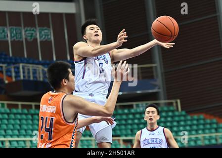 Zhuji, provincia cinese di Zhejiang. 5 novembre 2021. GU Zeyu (TOP) di Tianjin Pioneers passa la palla durante la nona partita di round tra i pionieri di Tianjin e gli squali di Shanghai alla stagione 2021-2022 del campionato dell'Associazione Cinese di Basket (CBA) a Zhuji, provincia di Zhejiang della Cina orientale, 5 novembre 2021. Credit: Chen Xinbo/Xinhua/Alamy Live News Foto Stock