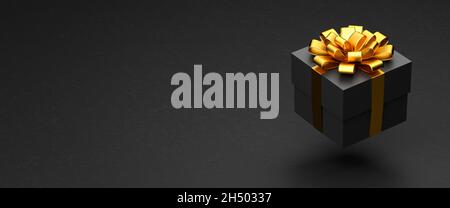 Una scatola presente scura con nastro dorato e arco che si sovrappone ad uno sfondo di pietra nera. Spazio di copia - dimensione banner Web Foto Stock