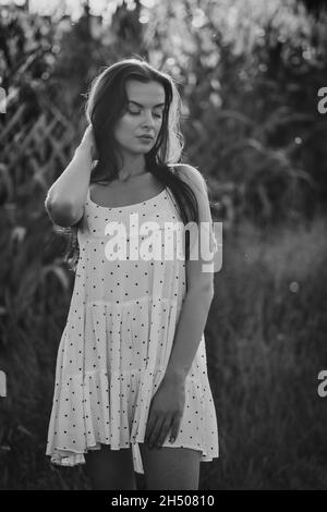 Giovane bella donna in abito bianco in campo di mais. Foto Stock