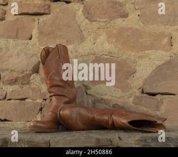 Stivali da cowboy in pelle marrone in un ambiente naturale Foto Stock