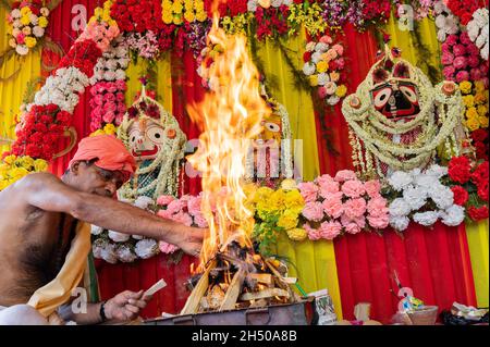 Howrah, Bengala Occidentale, India - 29th Giugno 2020 : sacerdote indù che alza il fuoco di yajna per adorare l'idolo di Dio Jagannath, Balaram e Suvodra. Foto Stock