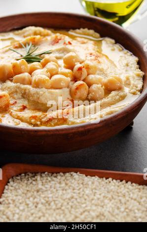 Vista da vicino a Hummus con fagioli olio d'oliva e foglie di rosmarino verde sul tavolo da cucina Foto Stock