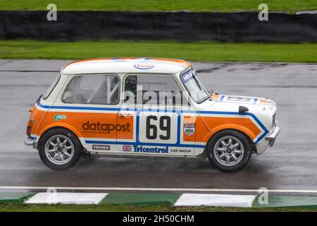 1978 Mini 1275 GT con il pilota Steve Jones durante il Gerry Marshall Trophy si riscalda al Goodwood 78° Members Meeting, Sussex, Regno Unito. Condizioni di umidità. Foto Stock