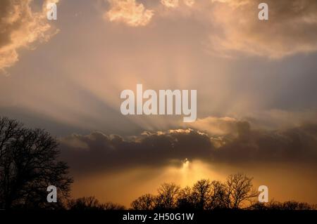 Le nuvole di tempesta drammatiche di sera, con raggi di sole che brillano attraverso le nuvole vicino al tramonto Foto Stock