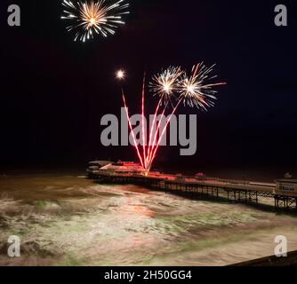 Cromer, Norfolk, Inghilterra - 1 gennaio 2019 esposizione di fuochi d'artificio in rosso e verde sul Molo di Cromer nuovo giorno di anni preso da una posizione elevata durante un stor Foto Stock