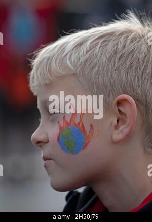 COP26 venerdì per il futuro, Climate Strike, Kelvingrove Park, Glasgow, Regno Unito. 5 novembre 2021. L'attivista ambientale Greta Thunberg ha lanciato un appello a Glaswegiani e ad altri per unirsi alla protesta. Organizzato da venerdì per la futura Scozia, con i partecipanti che marciano alle 11:30 da Kelvingrove Park a George Square che terminano la marcia verso le 14:40 per i discorsi a George Square. Foto Ruaridh con il mondo su tatto vernice fuoco dipinto sulla sua guancia.Credit: Arch White/Alamy Live News Foto Stock